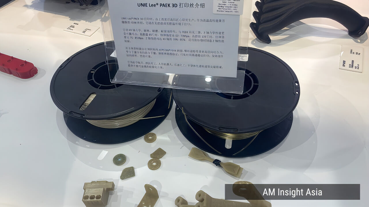 UNIE Lee® PAEK filament on display at the Bambu Lab booth, alongside printed sample parts.