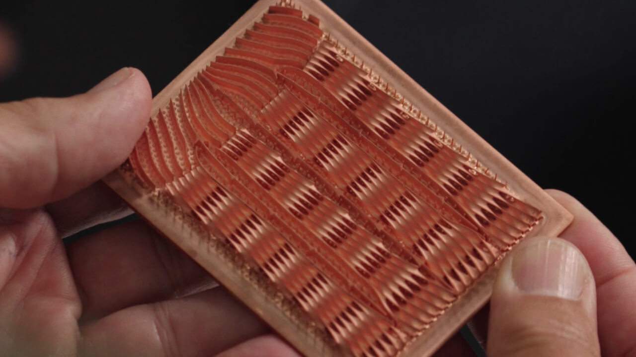 The internal structure of an ECAM-printed copper cold plate. The wavy fins and microscale channels are formed as a single piece through additive manufacturing. | Video still: Fabric8Labs