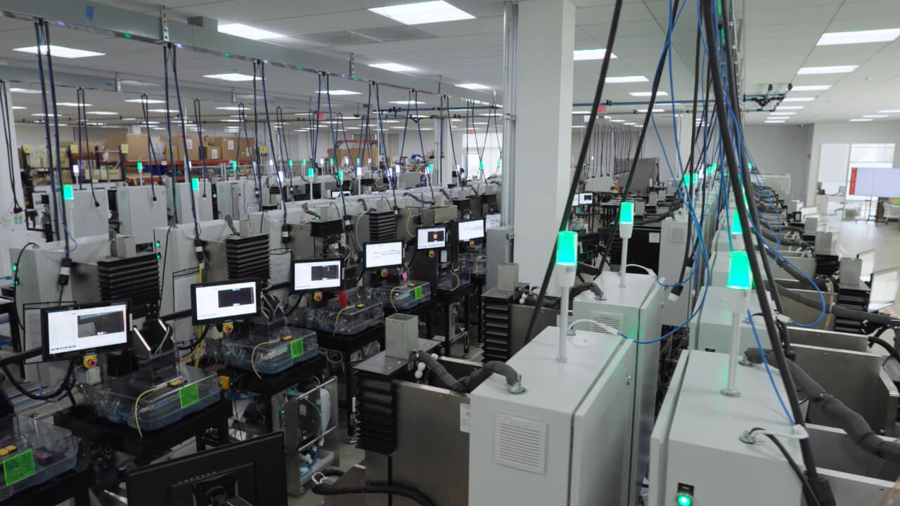Fabric8Labs' production floor, where rows of ECAM printers support the company's mass-manufacturing operations. | Video still: Fabric8Labs