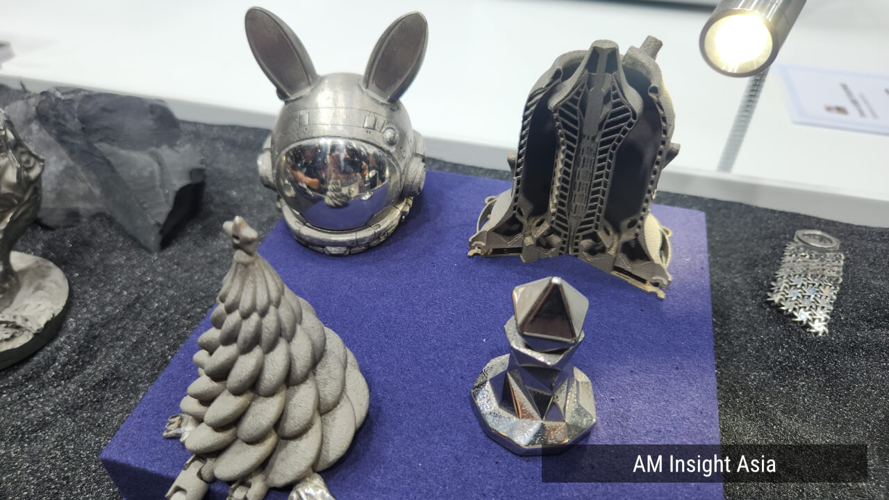 Display pieces, some left as printed and some polished to a mirror finish. At the back right is a cross-section of a printed part. | Photo: AM Insight Asia